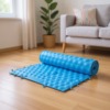 Mata d’acupression pour les pieds, étalée sur le sol du salon
