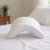 Un oreiller en mousse à mémoire de forme, à la forme incurvée, pour soutenir ton bras au lit, dans ta chambre.