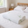 Un oreiller en mousse à mémoire de forme avec une housse en bambou, posé sur le lit dans la chambre. Un oreiller en mousse à mémoire de forme avec une housse en bambou, posé sur le lit dans la chambre.
