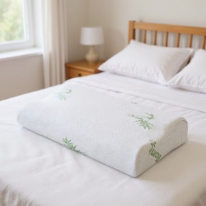 Un oreiller en mousse à mémoire de forme avec une housse en bambou, posé sur le lit dans la chambre. Un oreiller en mousse à mémoire de forme avec une housse en bambou, posé sur le lit dans la chambre.