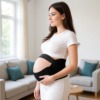 Un ceinture de grossesse réglable portée par la future maman Un ceinture de grossesse réglable portée par la future maman